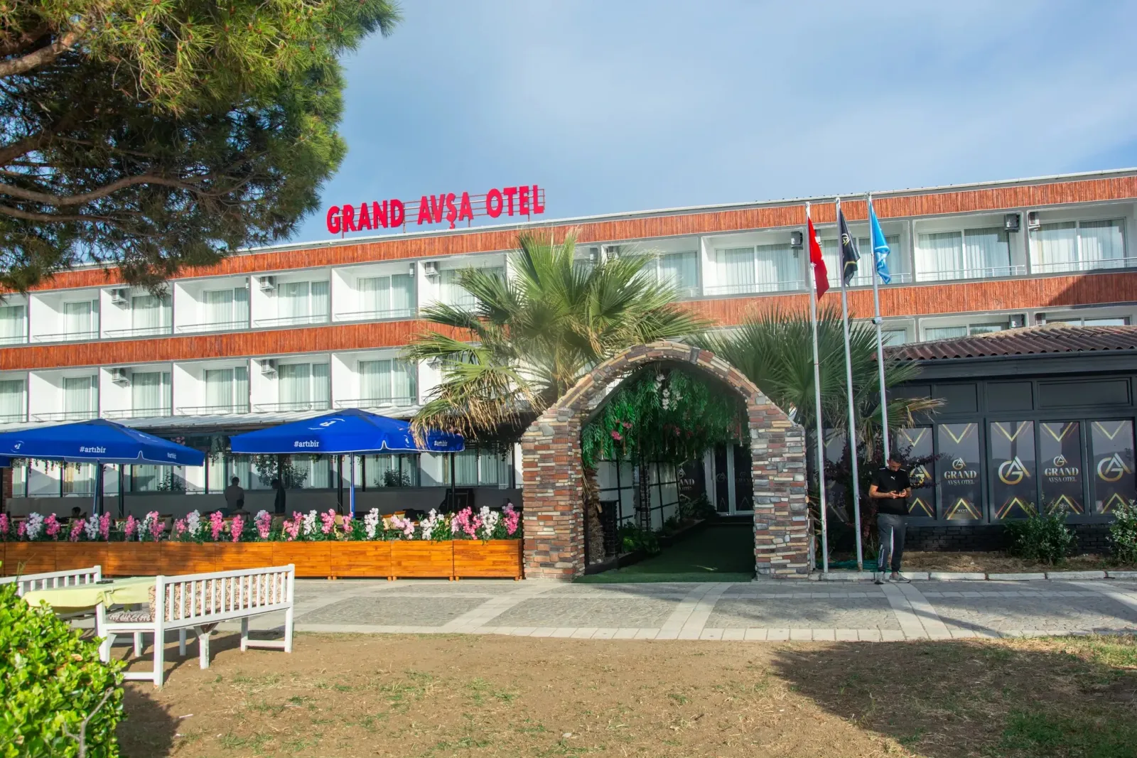 Grand Avşa Hotel dış görünüm — palmiyeli giriş ve sahil